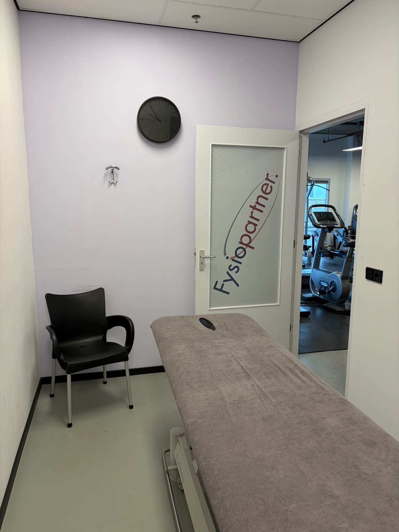 Behandelruimte met behandeltafel en Fysiopartner-deur
